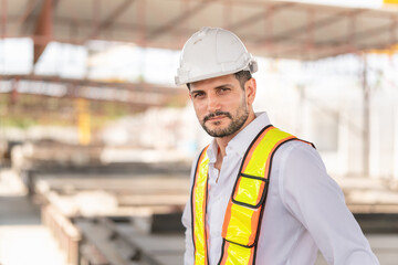 Portrait of a young engineer man in hardhat at a construction site