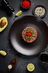 Tuna and avocado tartare on a dark ceramic plate