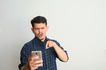 Angry Asian man in casual shirt get mad on the smartphone.