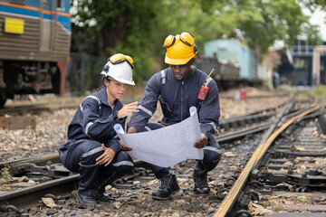 Railway Workers Discussing Plans on Railroad Track