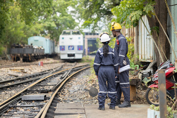Railway Workers Discussing Plans on Railroad Track