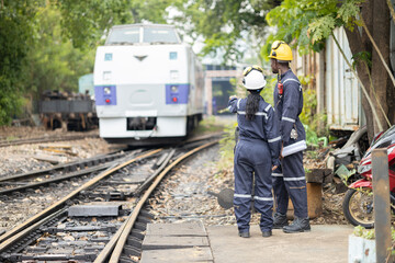 Fototapeta premium Railway Workers Discussing Plans on Railroad Track