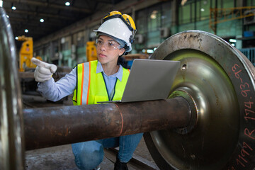 Engineer Analyzing Train Wheelset with Laptop in Depot