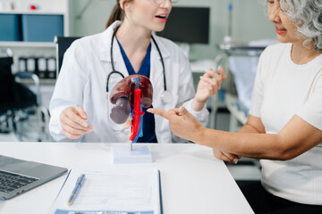 Doctor in white suit take notes while discussing and Asian elderly, man patient who lying on bed with receiving saline solution