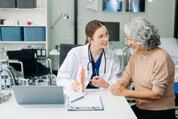 Doctor in white suit take notes while discussing and Asian elderly, man patient who lying on bed...