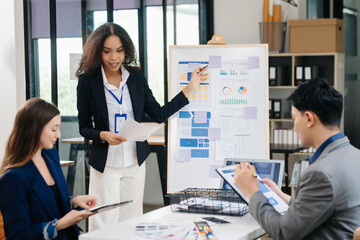 Group of young Asian business people discussing business plan at modern startup in creative business discussing work