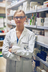 Serious, pharmacist or portrait of woman with arms crossed in healthcare clinic, pharmacy or...