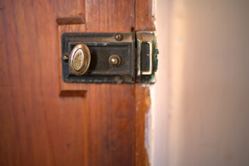 View of antique lock door with a half part of room wall.