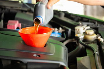 Refueling and pouring oil quality into the engine motor car Transmission and Maintenance Gear .Energy fuel concept.