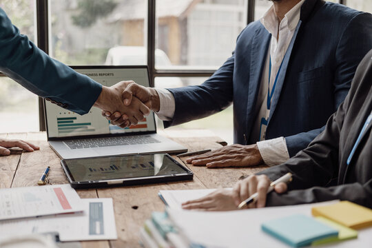 Businessmen shaking hands with sales reports and analysis documents shaking hands while coming to a mutual agreement after negotiations.
Close-up pictures