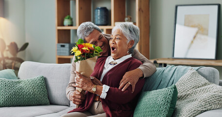 Senior man, flowers and woman on couch for surprise, anniversary and present for birthday in living...
