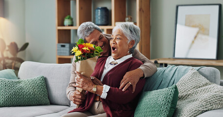 Senior man, flowers and woman on couch for surprise, anniversary and present for birthday in living room. Happy couple, elderly people and plants on home sofa for gift with love, smile and retirement