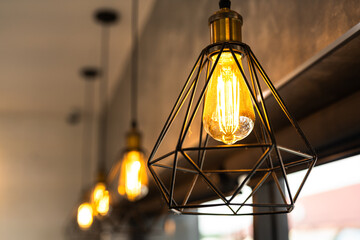 Classing ceiling lighting lamp with metal cage that glowing in warmlight shade. Interior decoration...