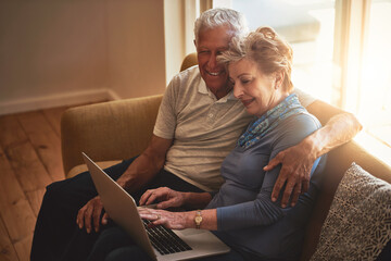 Senior, happy couple and sofa with laptop in browsing, online shopping or financial discussion at home. Elderly man and woman discussing retirement or pension fund on computer in living room at house