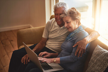 Senior, happy couple and sofa with laptop in browsing, online shopping or financial discussion at...