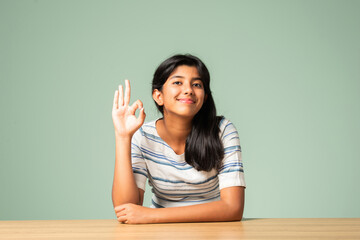 Indian asian small girl showing ok, perfect sign or thumbs up