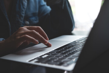 Close up of woman hand using laptop computer, browsing web and searching the information, surfing...