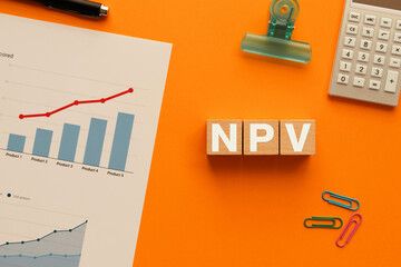 There is wood cube with the word NPV. It is an abbreviation for Net Present Value as eye-catching...