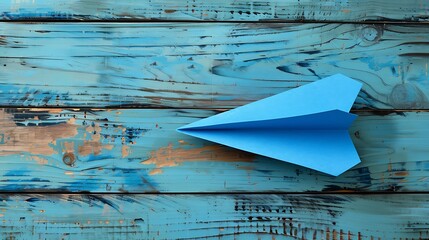 Blue paper plane on wooden background