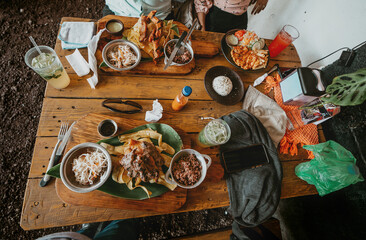 Top view of a table with traditional roast meats and gallopinto. Traditional roast beef with slices of banana and gallopinto served on a wooden table.