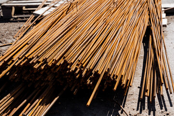 Closeup of rusty steel rebars at construction site creating a textured pattern. The heavy metal...