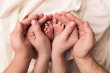 Children's feet in the arms of their parents. On a white background.