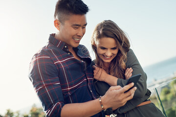 Happy couple, hug and laughing with phone on balcony for funny joke, post or meme on social media...