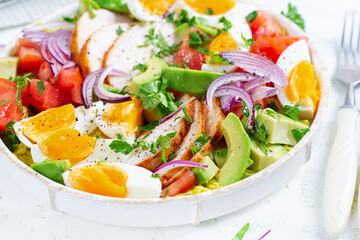 Healthy cobb salad with chicken, avocado, tomato, red onions and eggs. American food.