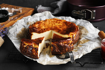 Tasty Basque burnt cheesecake on dark background sliced