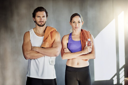 Towel, fitness and portrait of couple in gym for intense training, exercise and cardio workout. Sports, personal trainer and man and woman for wellness, healthy body and performance with water