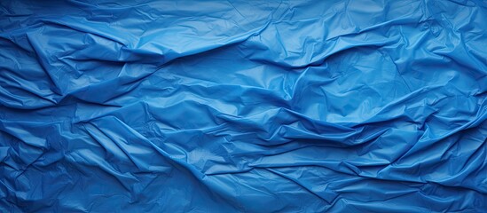 An abstract rough textured blue plastic wrinkle background with ample copy space image