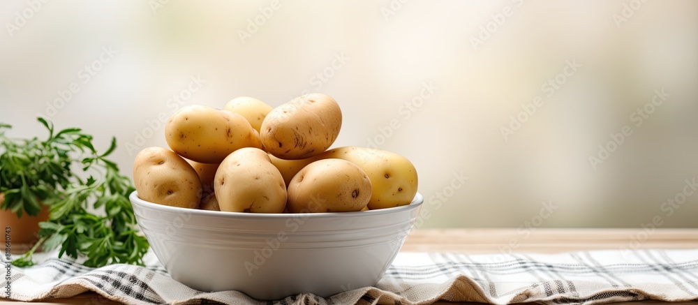 Poster the table is adorned with a bowl containing fresh pristine potatoes a kitchen towel complements the 