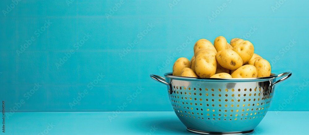 Poster Copy space image of a colander with a raw potato on a bright background