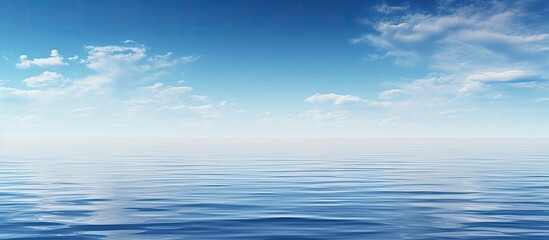 Obraz premium A serene scene with a clear blue sky mirrored in a calm blue ocean creating a captivating copy space image