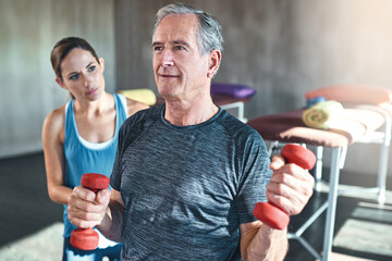 Physiotherapist, fitness and elderly man with dumbbell in clinic for rehabilitation, support or...