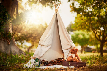 Teepee, tent and fun in garden in nature outdoor at park for playing, camp and imagination of...