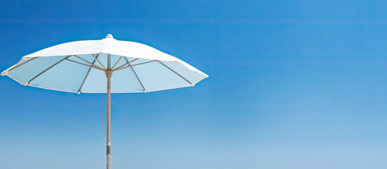 Closeup of a natural beach umbrella against a blue sky with copy space image