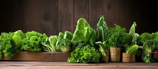 Green leafy vegetables including lettuce spinach and arugula are arranged on a vintage wooden table creating a rustic display There is ample space for additional content