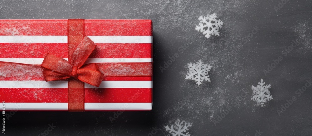 Poster A handmade box with red striped paper adorned with fir and snow represents the concept of Christmas and New Year Seen from above on a grey background there is ample copy space in the image