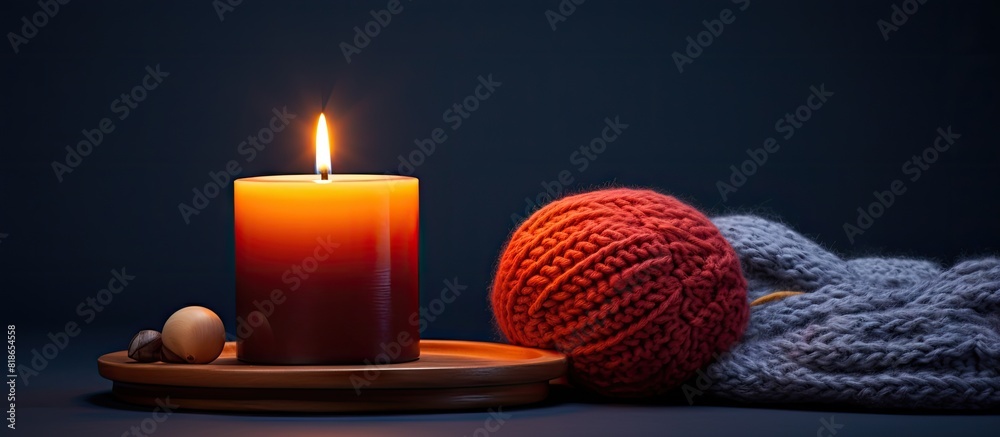 Poster An image capturing a still life composition featuring a lit candle alongside a knitted object. with copy space image. Place for adding text or design