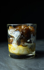 Glass of milk and frozen coffee cubes on black background 