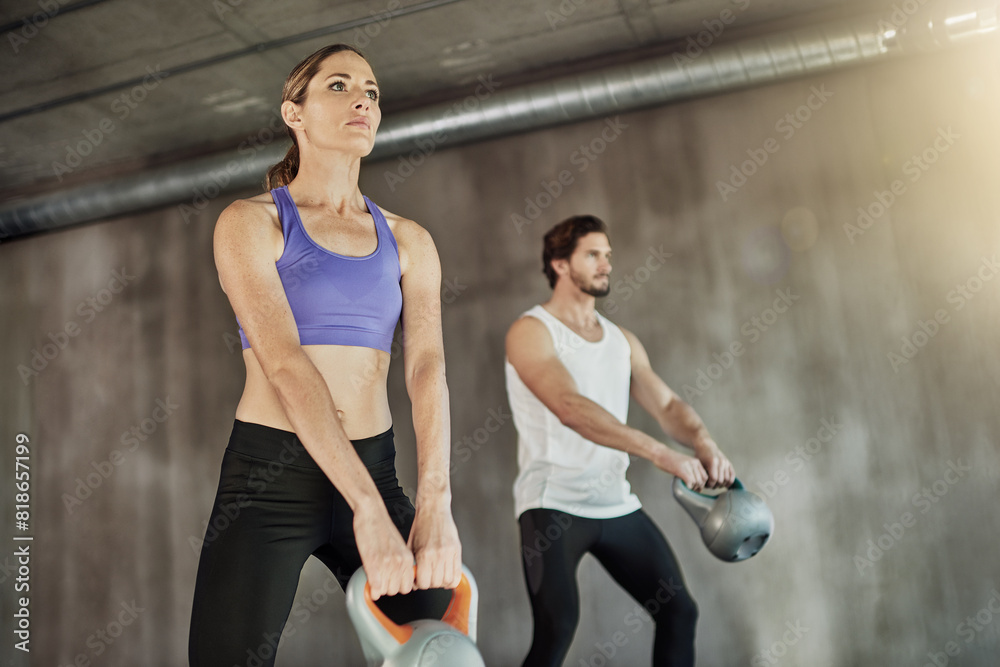 Wall mural Training, exercise and couple in gym with kettlebell, power and workout challenge together at sports club. Man, woman and personal trainer with weights, muscle development and healthy body fitness.