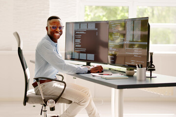 African American Coder Using Computer At Desk