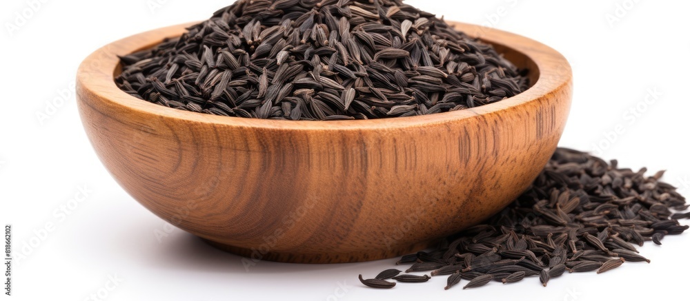 Poster Copy space image of black cumin seeds presented in a wooden bowl isolated on a white background The pile showcases nigella sativa seeds captured from various angles creating a diverse and visually ap