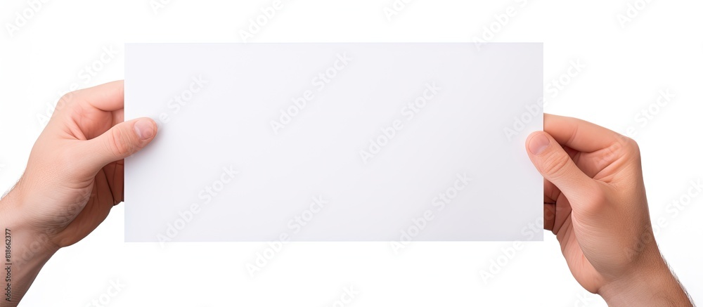 Poster a hand is holding a white piece of paper isolated on a white background with ample copy space for th