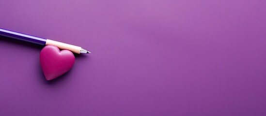 A high quality photo of a purple felt tip pen with a painted heart next to it representing a stationery concept with isolated copy space