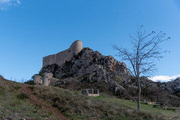 Fototapeta premium Impressive view of the medieval castle of Los Roja built on a hill surrounded by rocks in the province of Burgos at sunset
