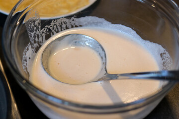 Close up of a lentils batter in glass bowl with a ladle