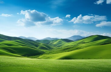 Green grassy hills with blue sky and mountains landscape background