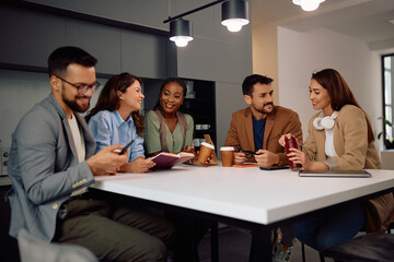 Happy creative business colleagues talking on  break in office.